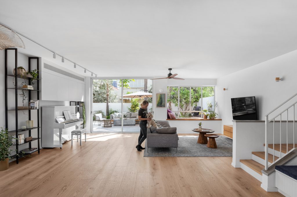 Open-plan space with a black bookcase and white stairs