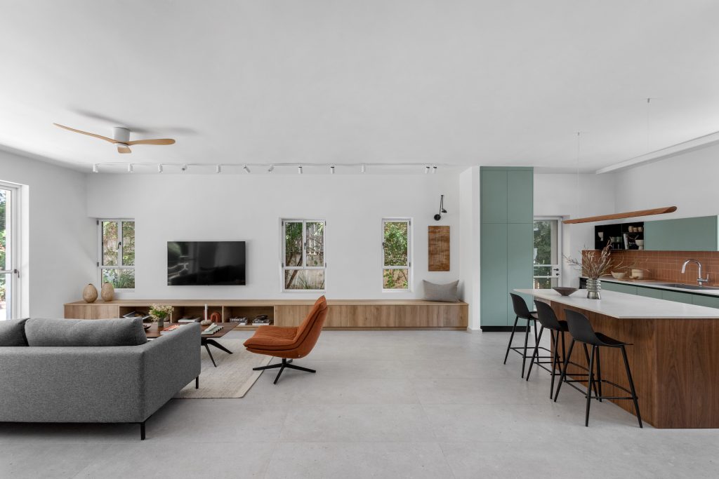 Living room and kitchen with a wooden island and black bar stools