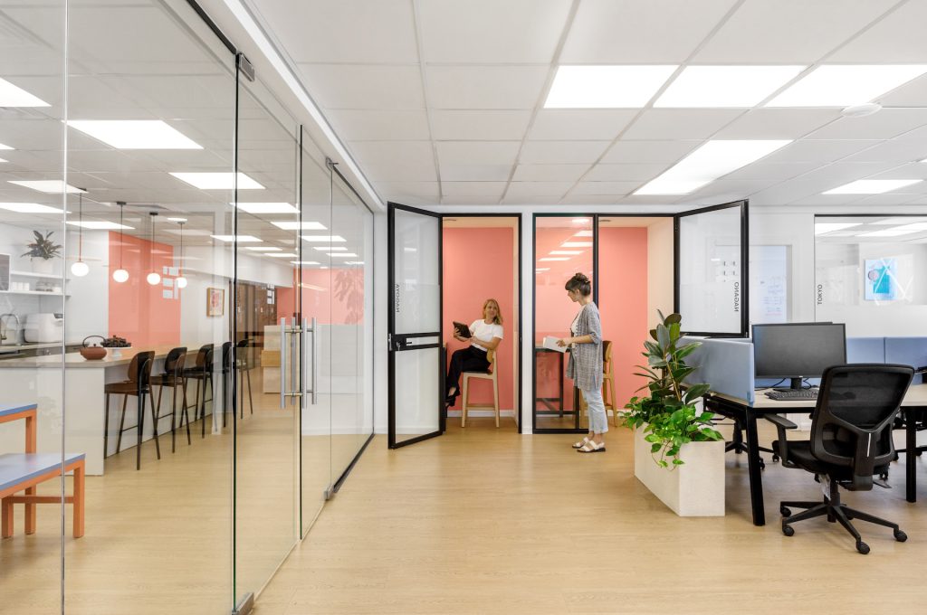 Glass meeting rooms with peach walls