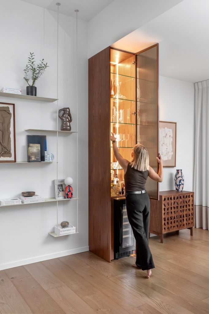 Lit walnut wine cabinet with a glass door