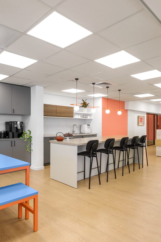 Office kitchenette with a bar and blue-and-orange benches, Commugen offices in Tel Aviv – Chen Shadmi, Shadmi Design