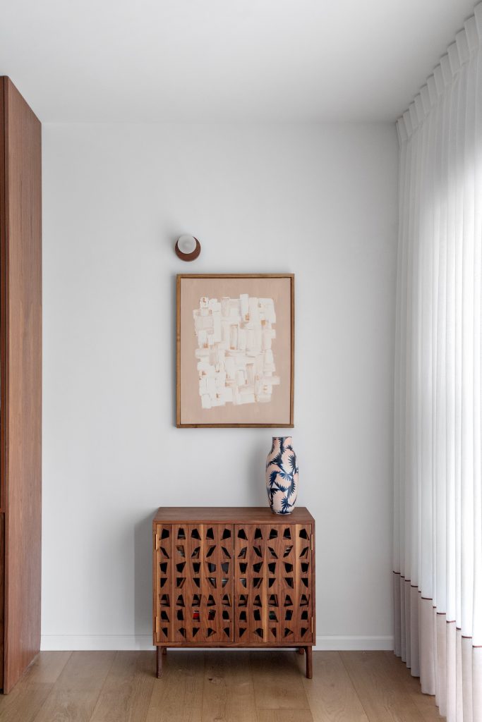 Carved wooden cabinet and an artwork in a white corner