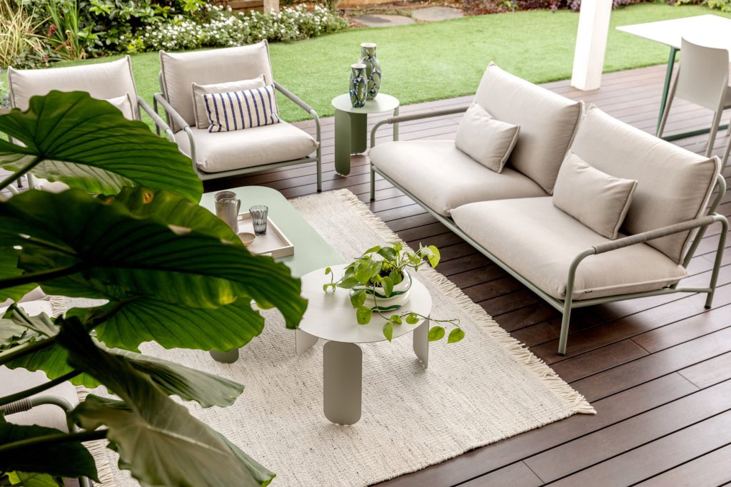 Light outdoor sofas and a woven rug on a garden deck