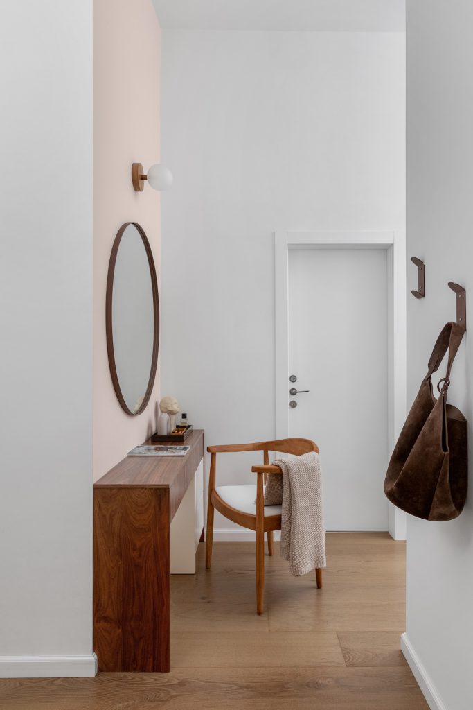 Dressing corner with a wooden desk and a round mirror