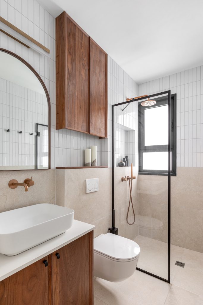 Bathroom with white tiles, a walnut cabinet and a black-framed shower