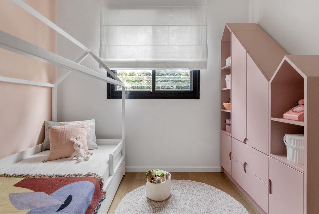 Girl's room with a house-frame bed and a pink house-shaped bookcase