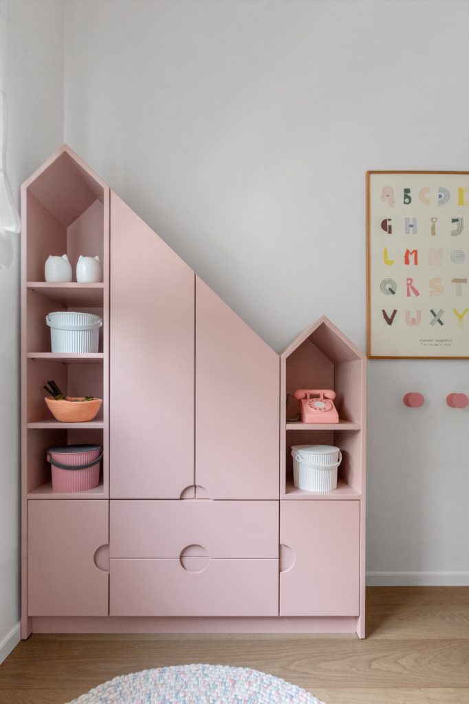 Pink house-shaped bookcase with open shelves