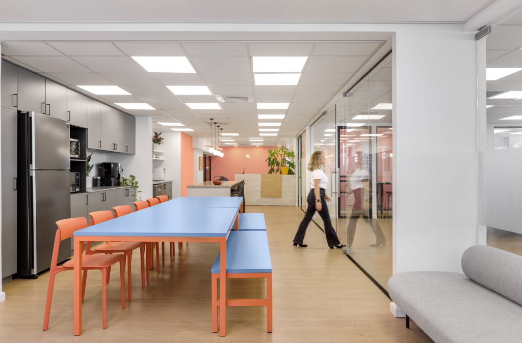 Kitchenette with a long blue table, looking along the office