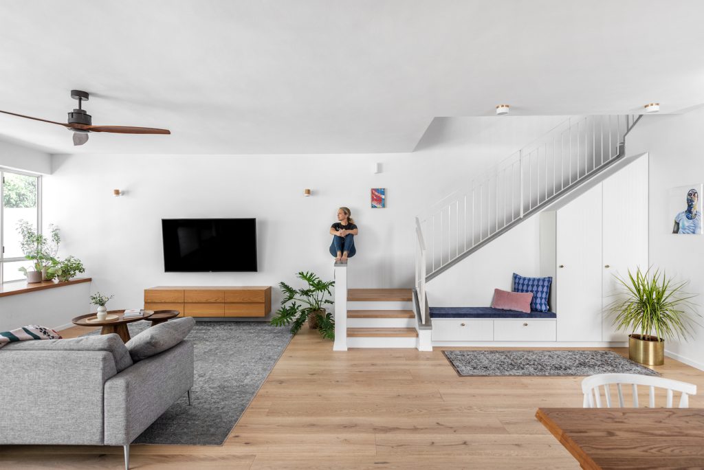 TV area facing stairs with an upholstered bench