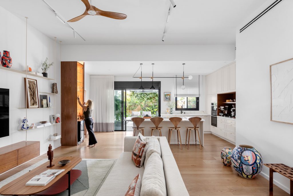 View from the living room to the kitchen and dining area, with a wooden ceiling fan