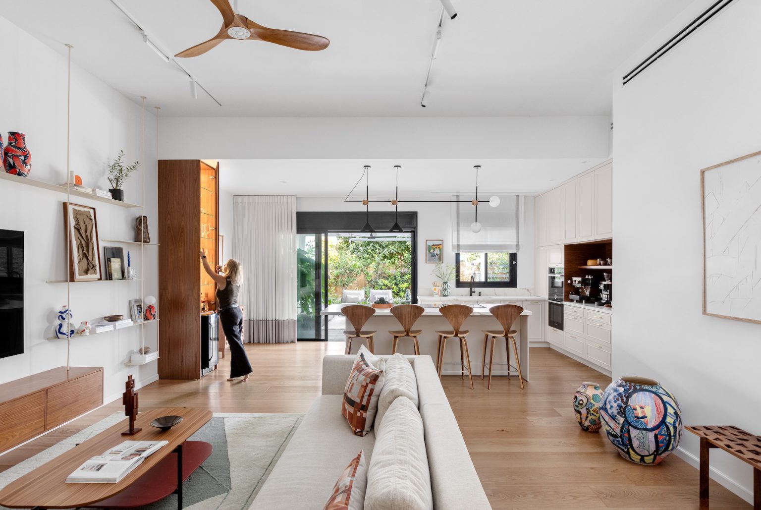 View from the living room to the kitchen and dining area, with a wooden ceiling fan