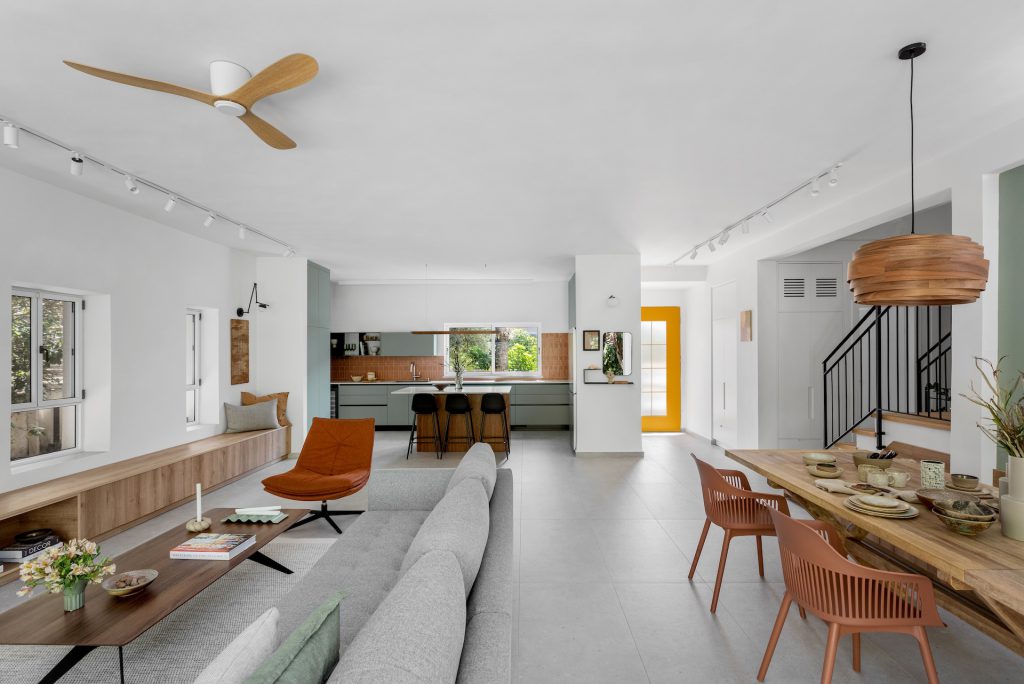 Long open-plan space with a built-in wooden bench and a wooden pendant