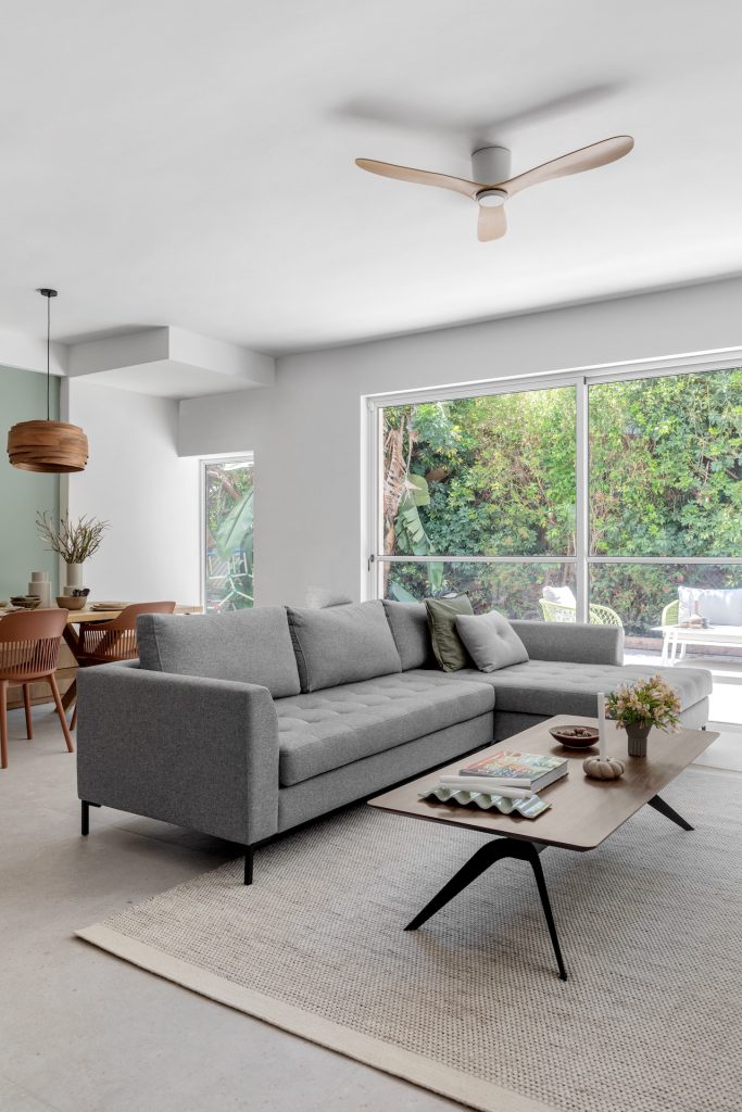 Grey sofa and wooden coffee table facing a garden window