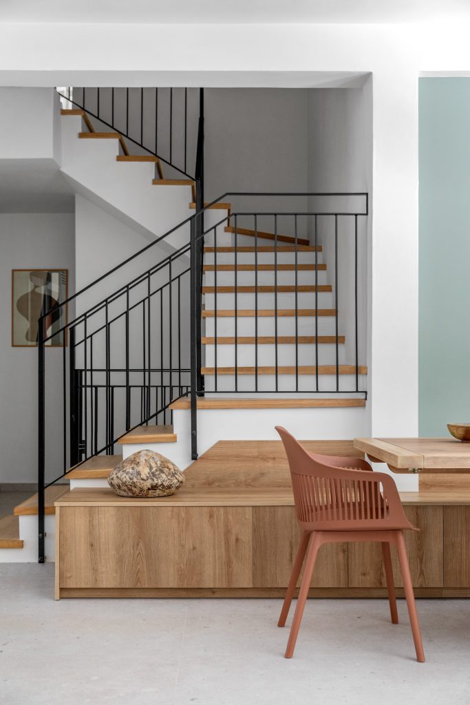 Staircase with a black railing above a wooden bench