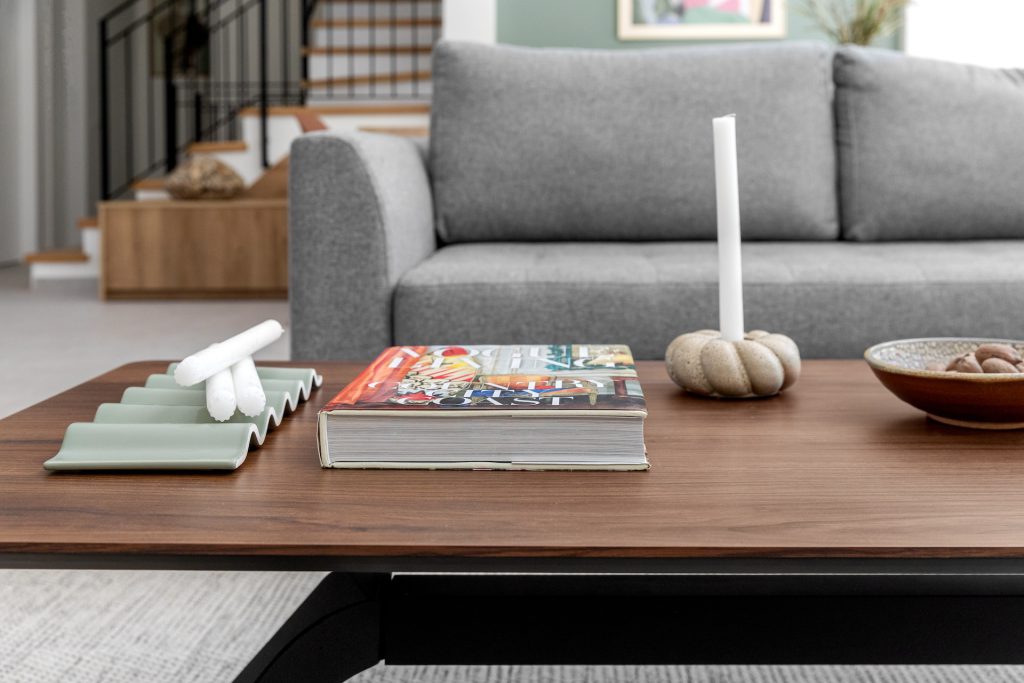 Detail: wooden coffee table with books in front of the sofa