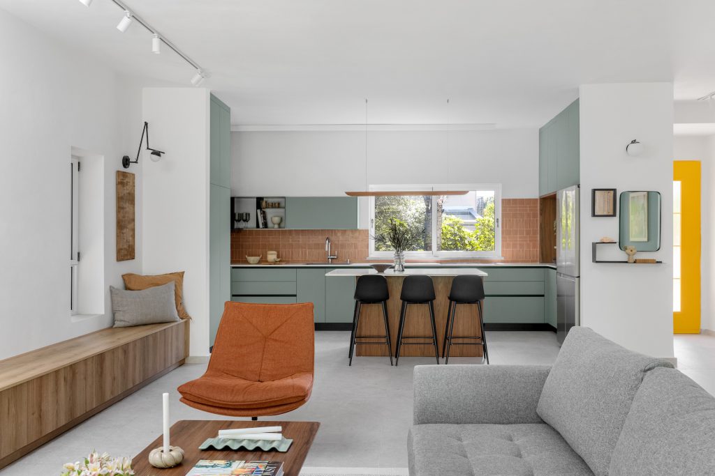 View from the living room to the kitchen, with a rust armchair