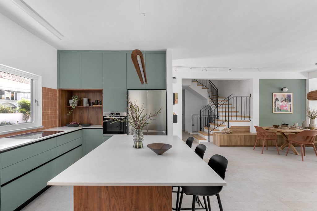 White kitchen island on a wooden base, looking to the stairs
