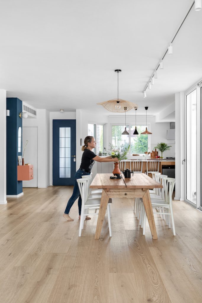 Long dining table under a wicker pendant