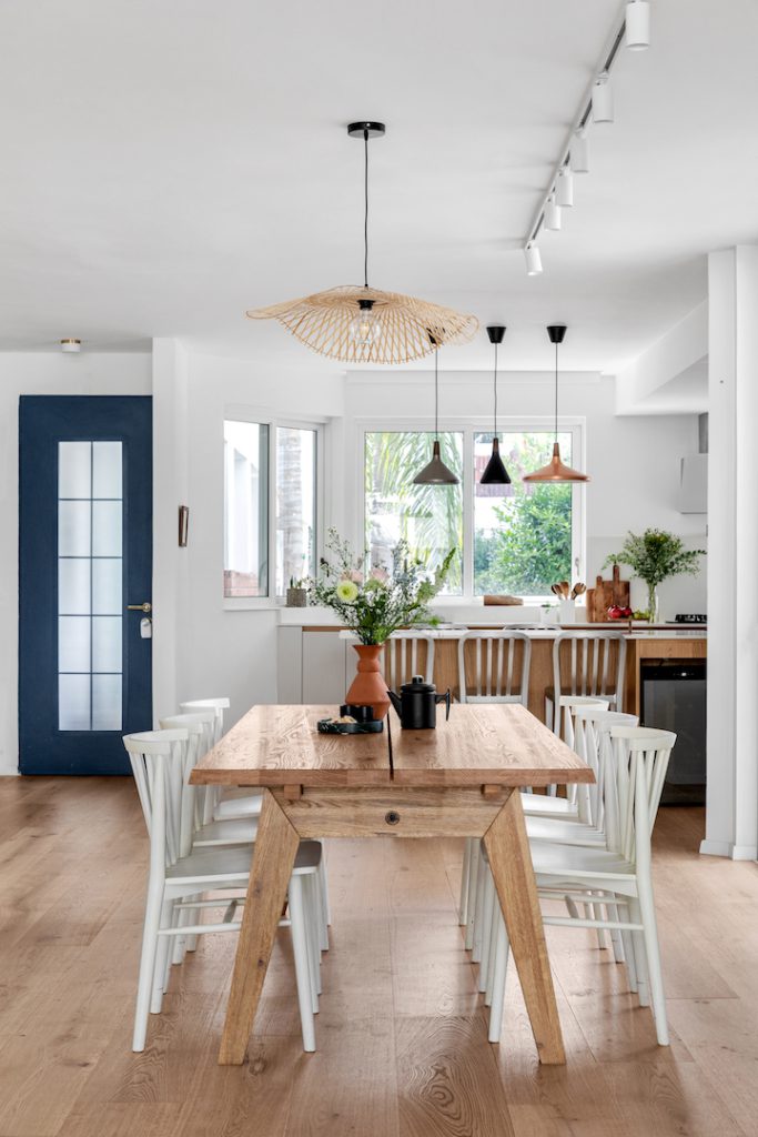 Wooden table and white chairs, looking to the kitchen