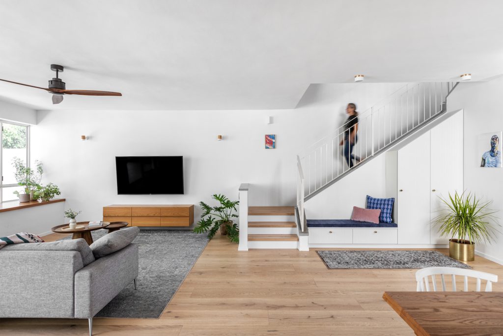 White stairs with a blue upholstered bench beneath