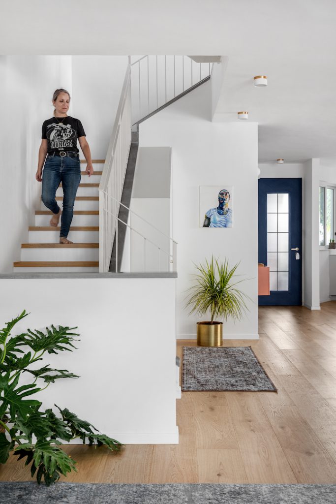 Wooden stairs with a white railing by the entrance