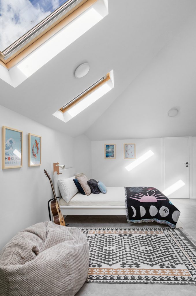 Attic bedroom with roof windows and a patterned rug