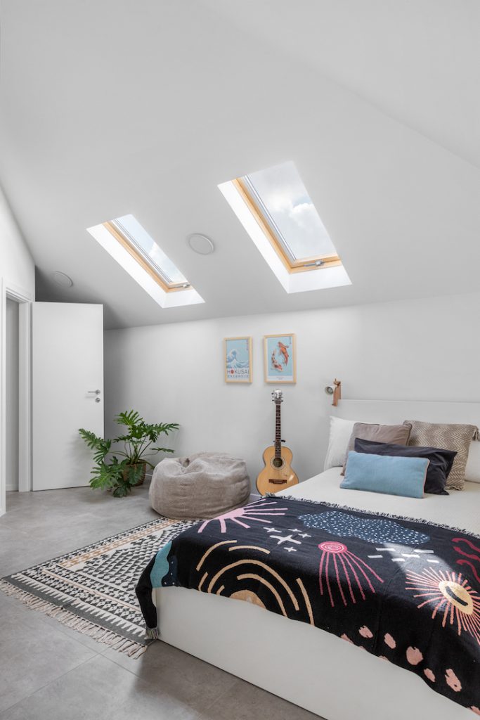 Attic bedroom with a sloped ceiling and black patterned bedding