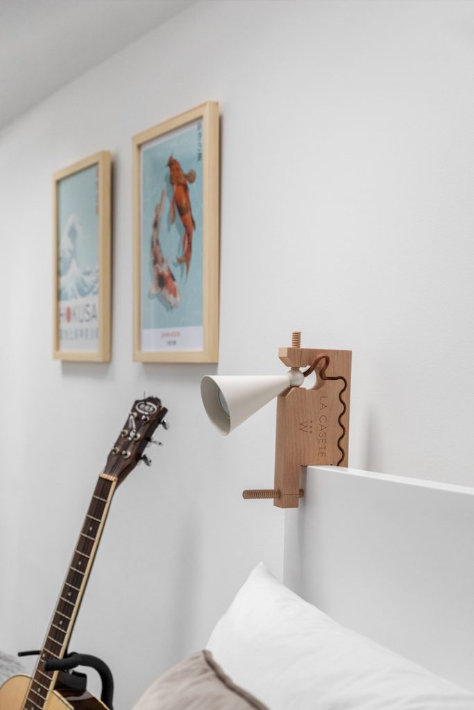 Detail: guitar, reading lamp and two framed prints