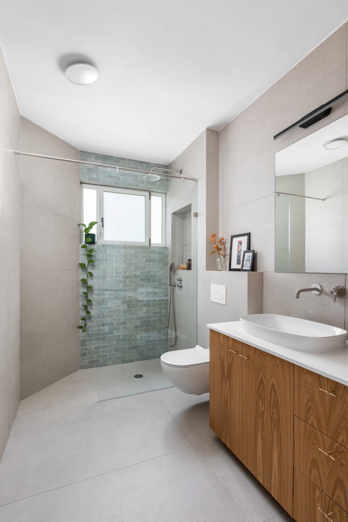 Bathroom with a wooden vanity and a walk-in shower