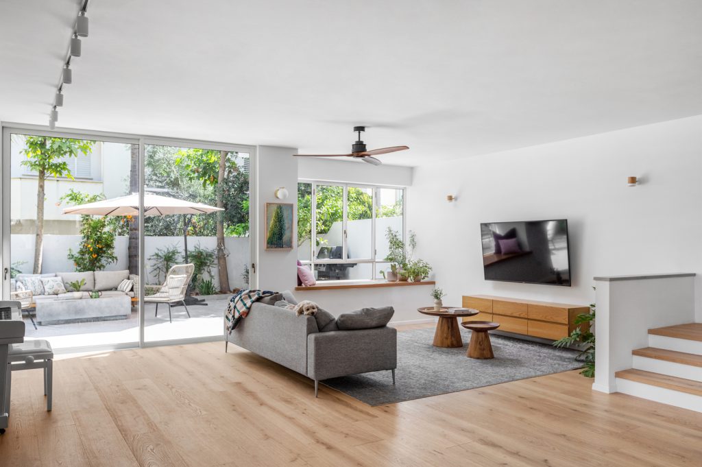 Living room with a wooden ceiling fan and windows to the garden
