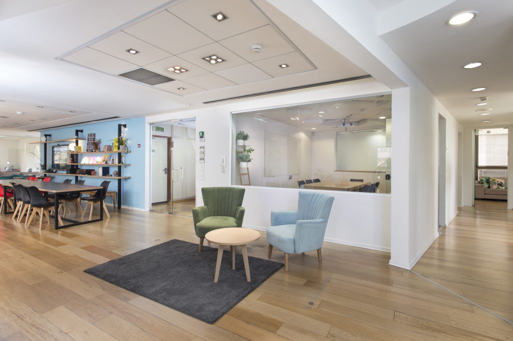 Seating corner with a round wooden table and a grey rug