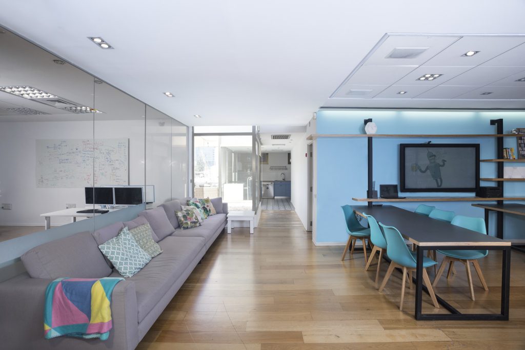 Long grey sofa beside the shared desks