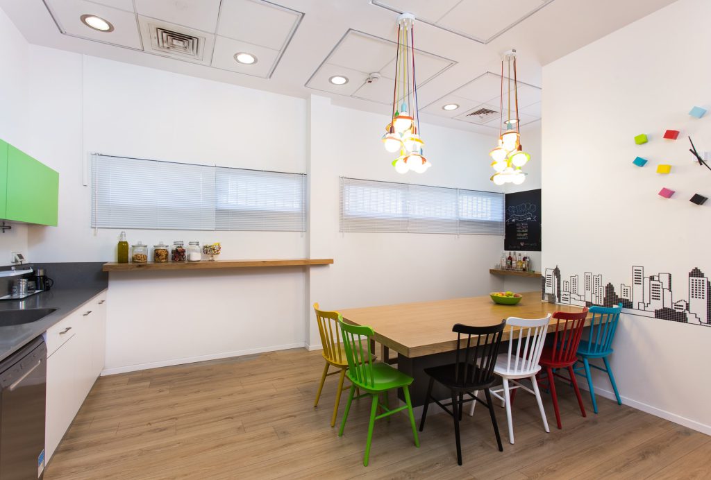 Kitchenette with a wooden table and colourful wooden chairs