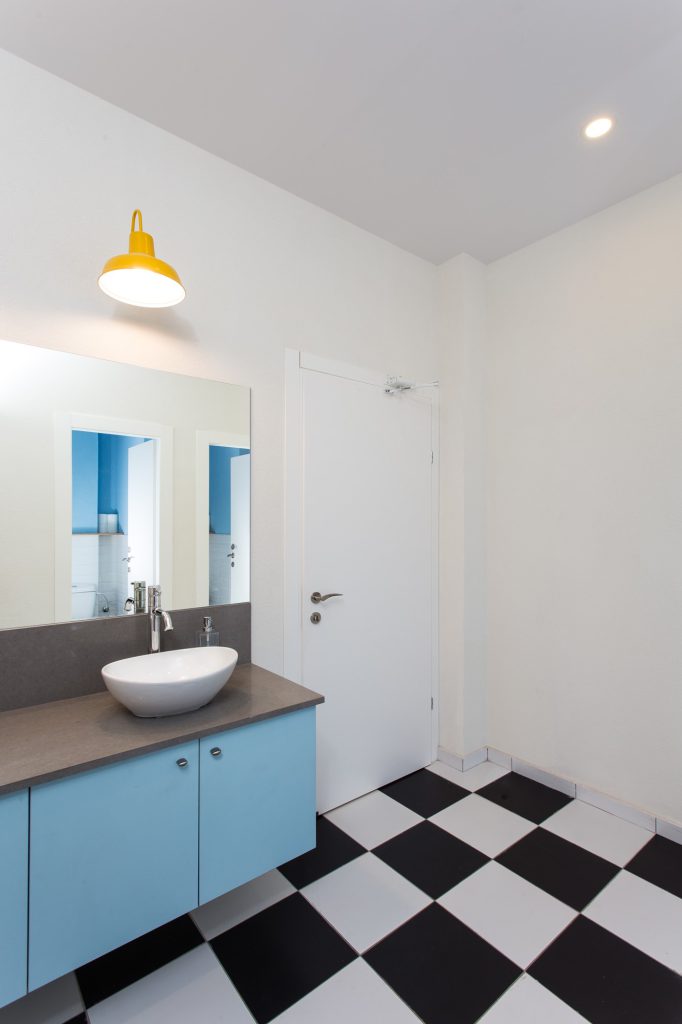 Bowl basin on a light blue cabinet over a chequerboard floor