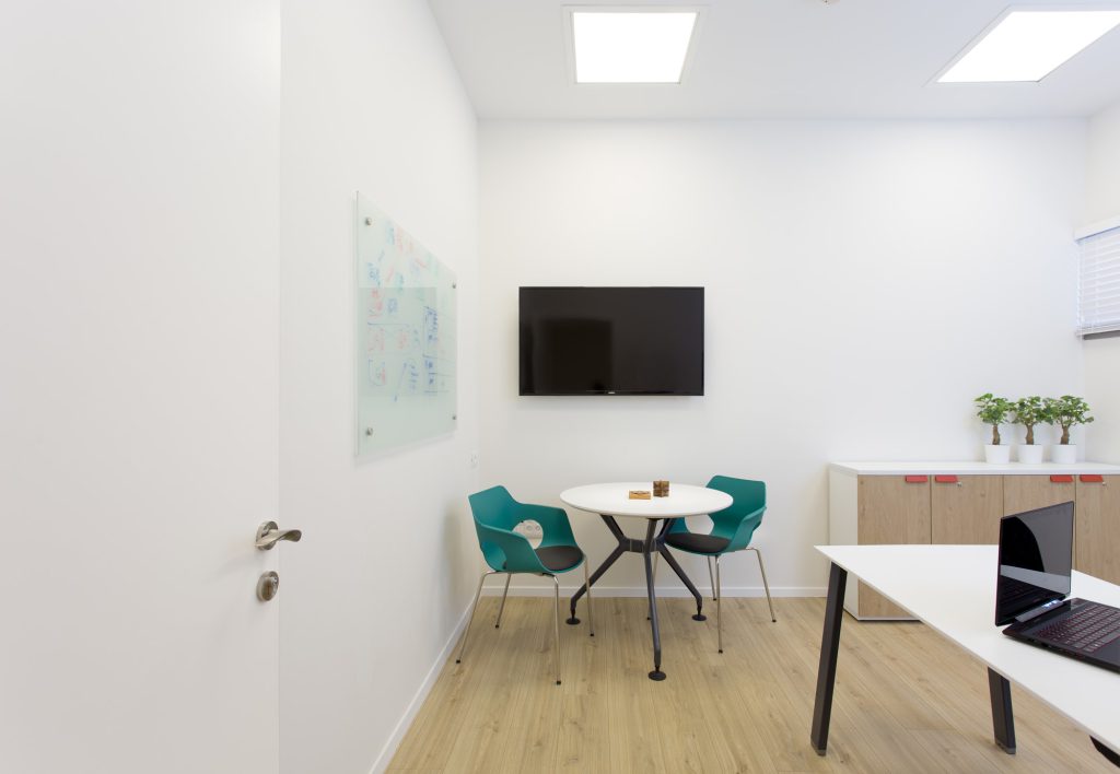 Small meeting room with a round table and teal chairs