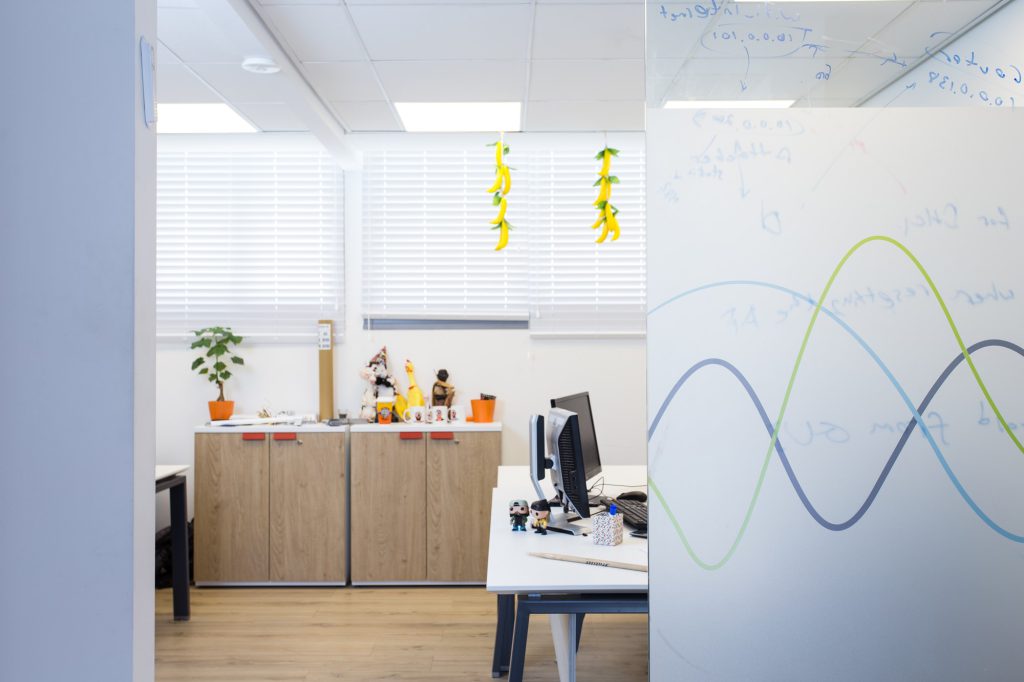 Glass partition with a wave graphic beside workstations