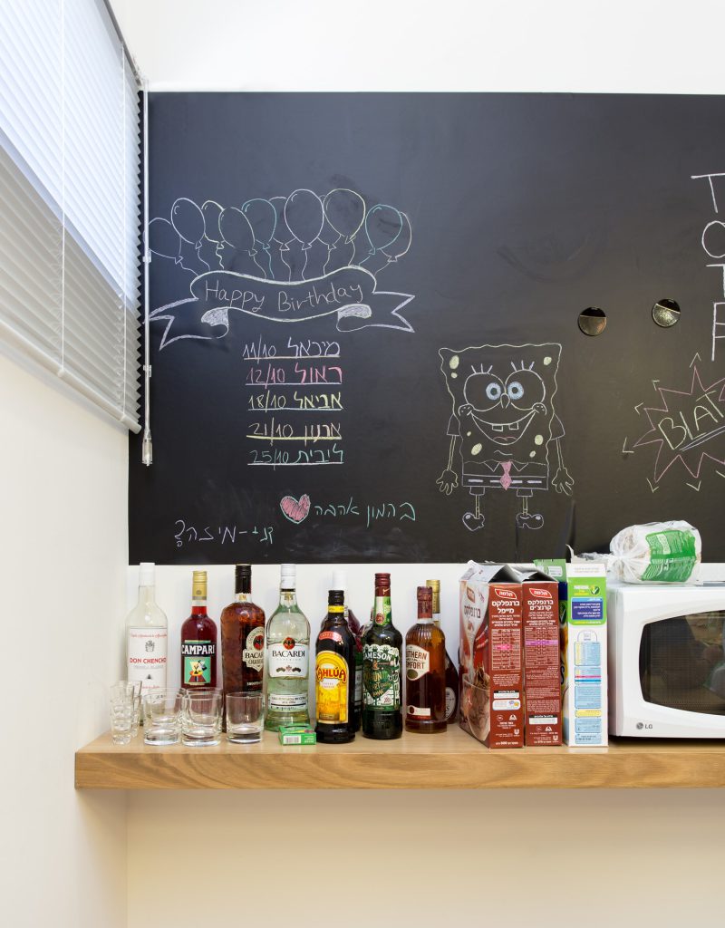 Chalkboard wall and a wooden shelf in the kitchenette