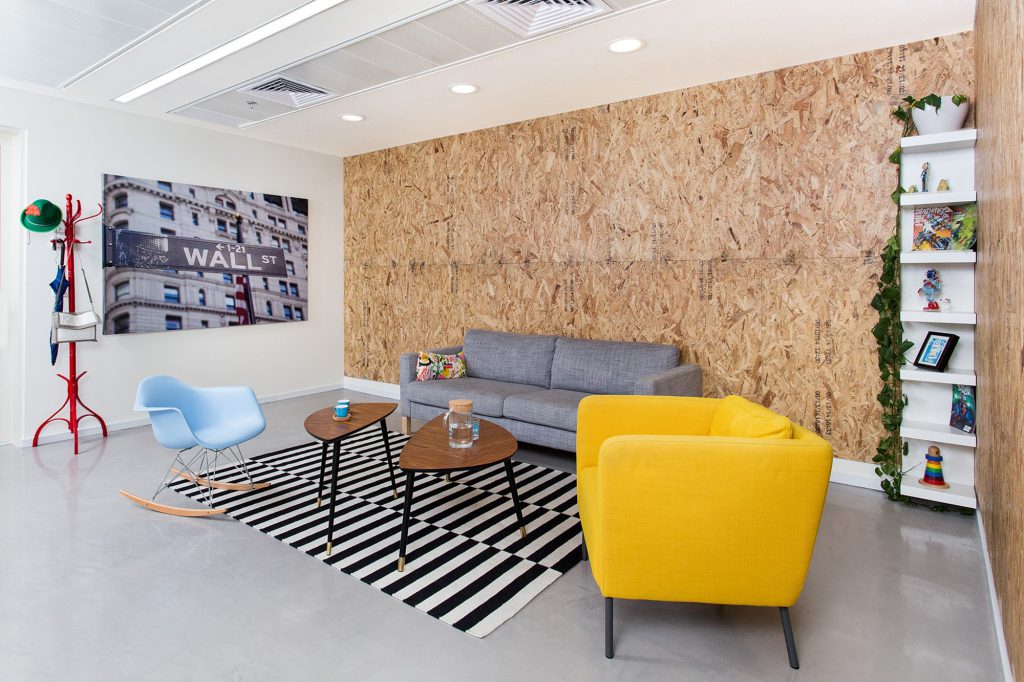 Seating area with colourful armchairs and a red coat stand