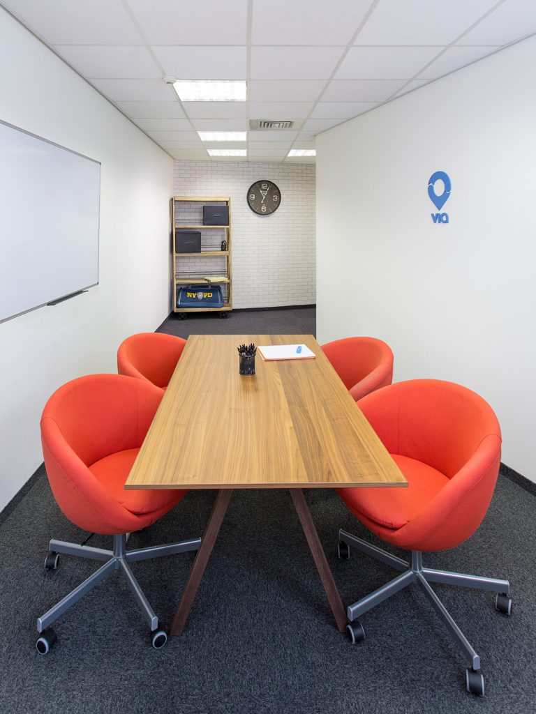Meeting room with a wooden table and orange chairs