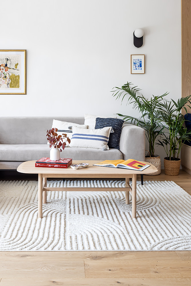 Wooden coffee table and a palm beside the sofa