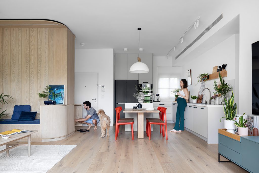Open kitchen with a wooden dining table and red chairs