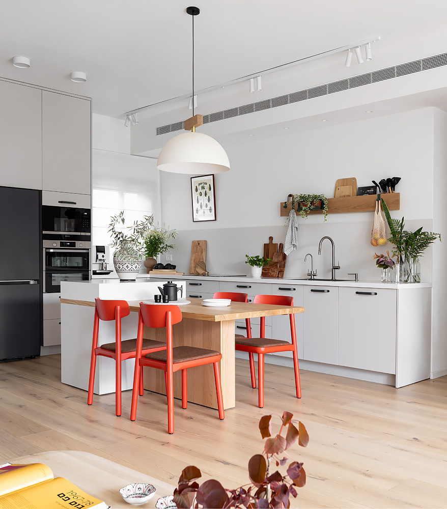 White kitchen with a pendant lamp over the dining table