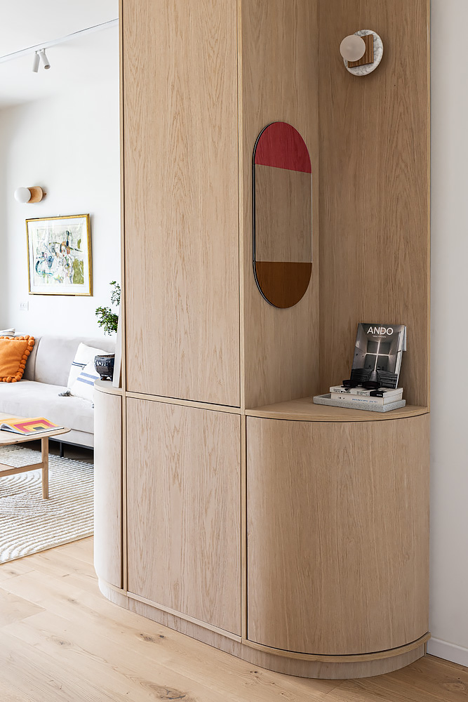 Rounded wooden entrance cabinet with an oval mirror