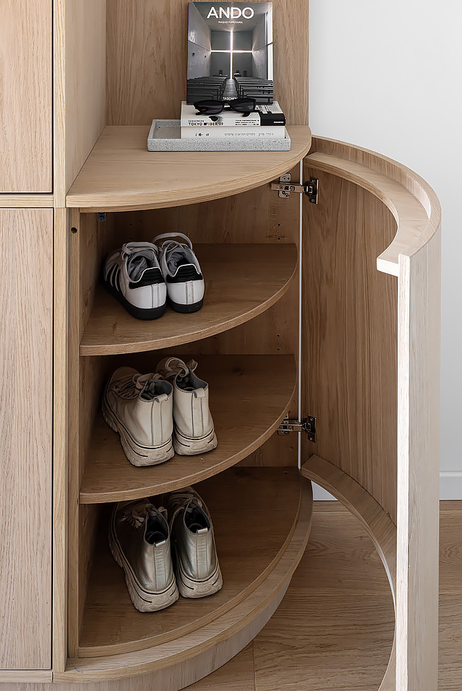 Detail: curved shoe shelves inside a wooden cabinet