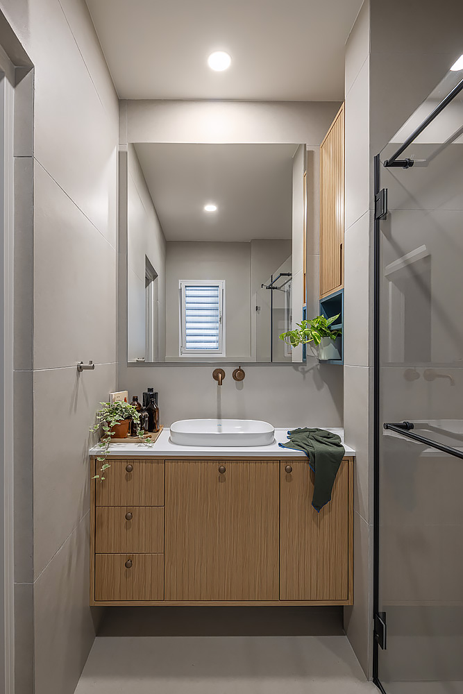 Bathroom with a wooden vanity and a rectangular mirror