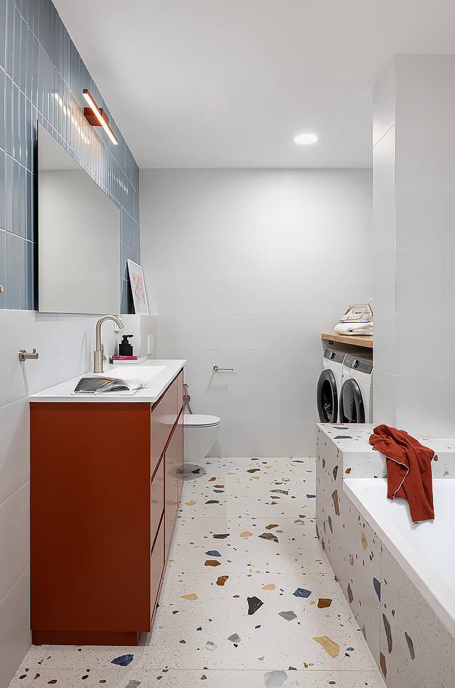 Bathroom with a brick-red vanity and colourful terrazzo floor