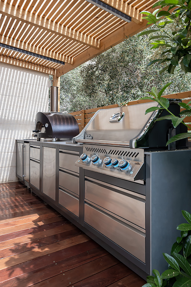 Stainless steel outdoor kitchen under a wooden pergola