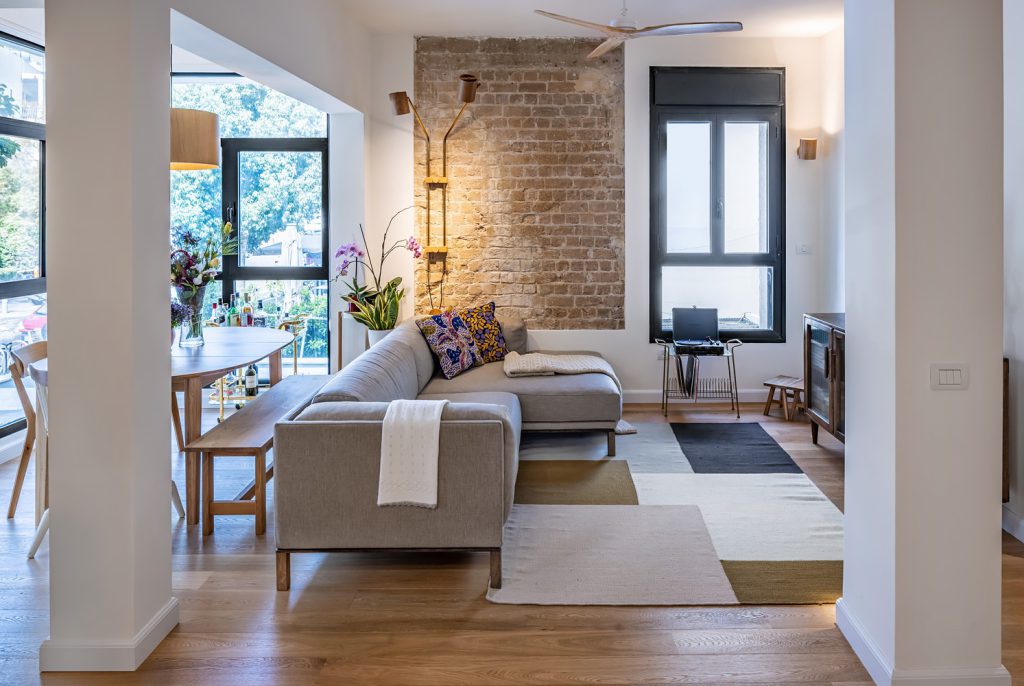 Living room with an exposed brick wall and a grey corner sofa