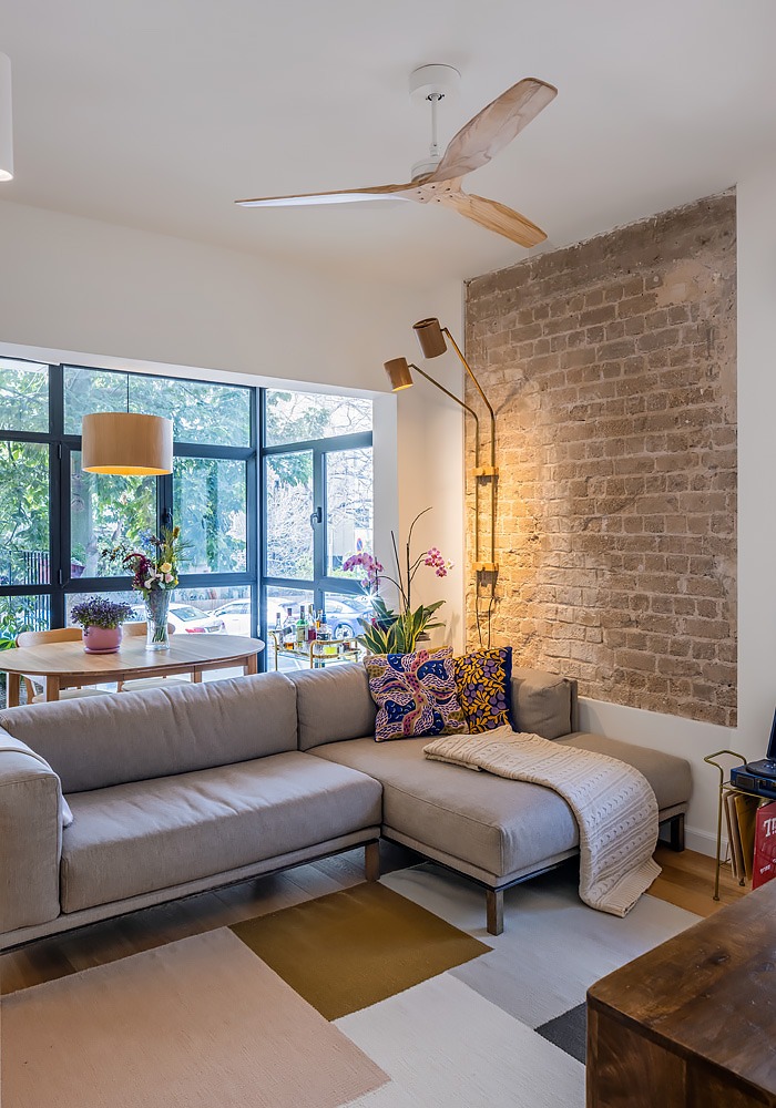 Corner sofa and ceiling fan facing windows to the trees
