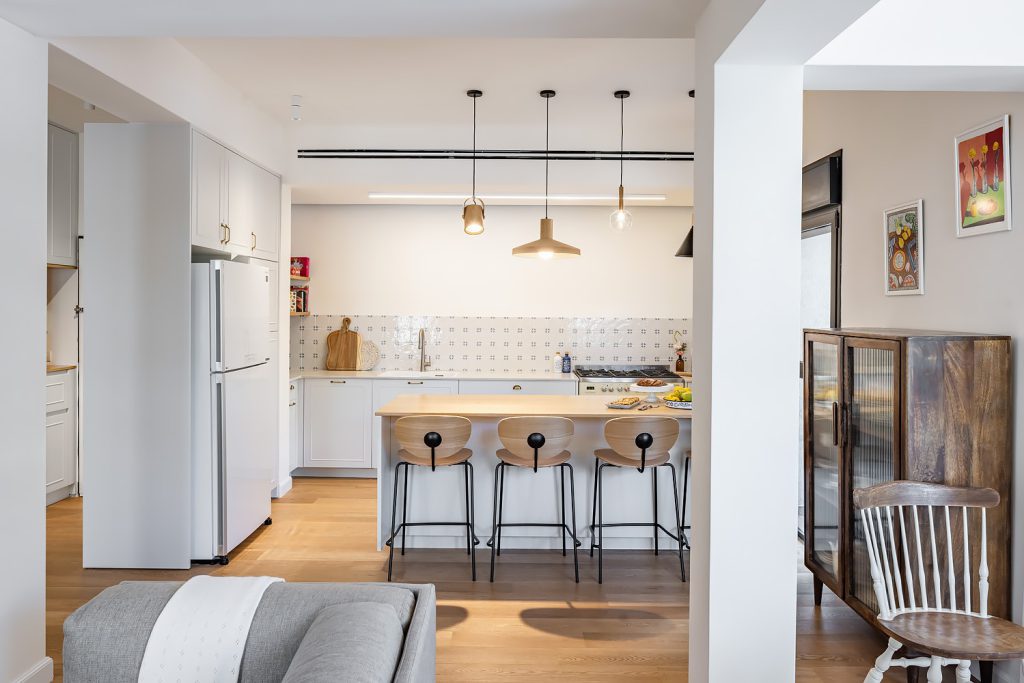Kitchen with a wooden island, pendant lights and a wooden display cabinet